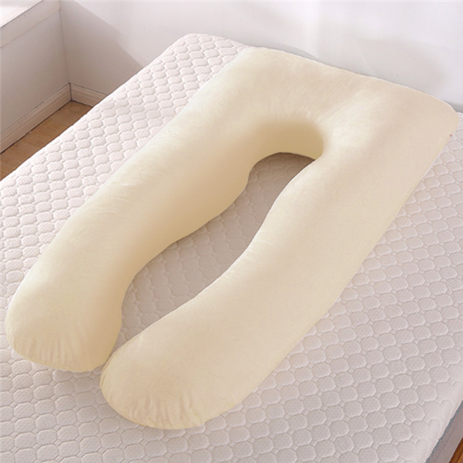 Beige U-shaped pillow on a textured surface