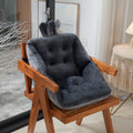 Wooden chair with dark gray cushion in a room setting; featuring ergonomic design with tufted cotton filling