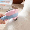 Pink and blue pet grooming brush being used on a white animal's fur
