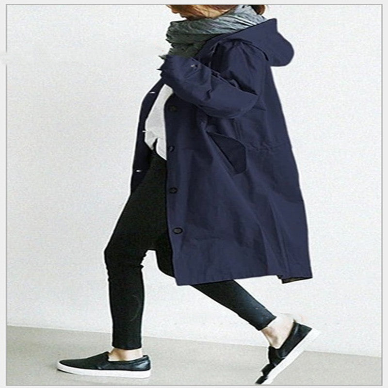 Person wearing a navy blue coat with a hood on a white background