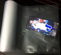 Phone displaying a basketball player on a screen with a roll of silver material next to it; Custom cut vacuum roll bags for freezer storage