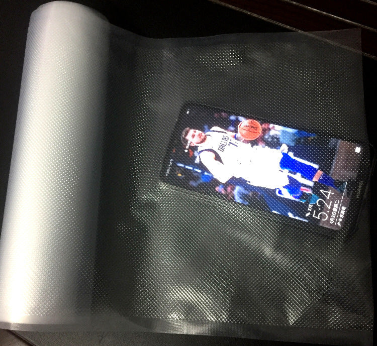Phone displaying a basketball player on a screen with a roll of silver material next to it; Custom cut vacuum roll bags for freezer storage