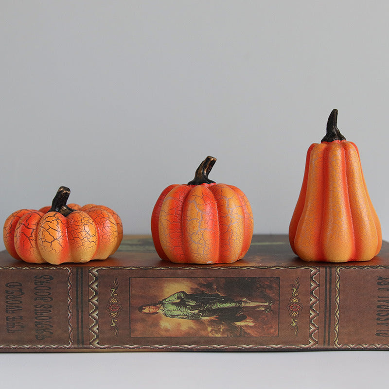 Three decorative Halloween pumpkins on an old book with a gray background