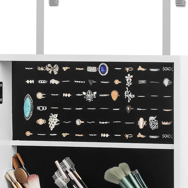 Display of various rings on a black card with makeup brushes below.
