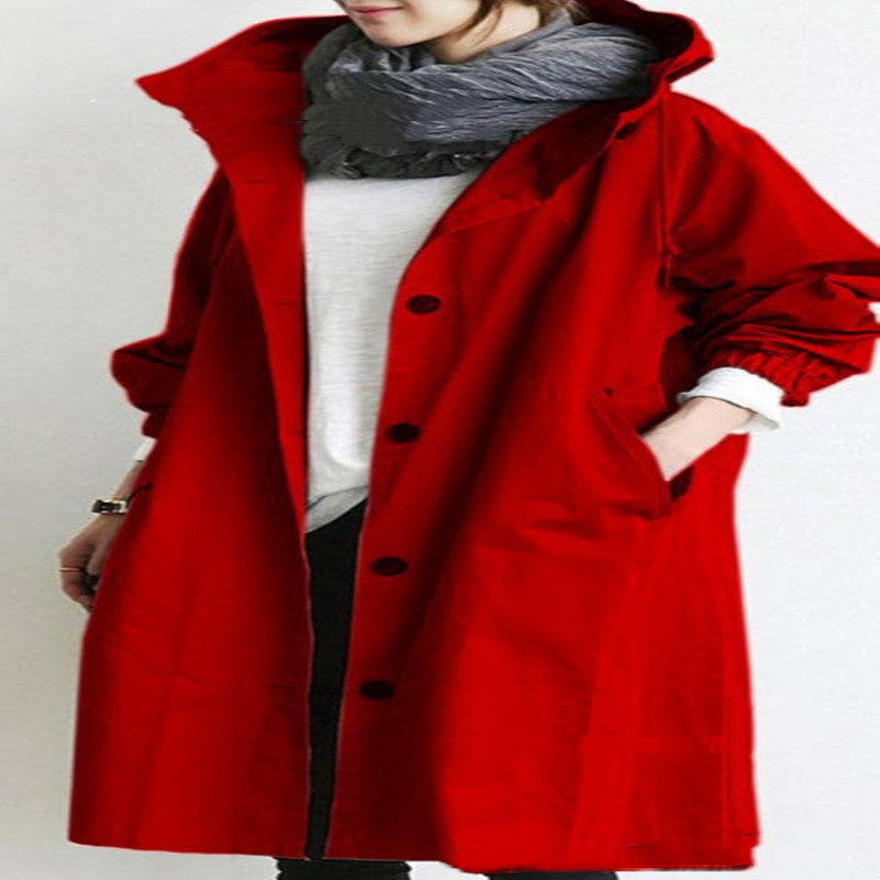 Person wearing a red coat with a hood on a plain background